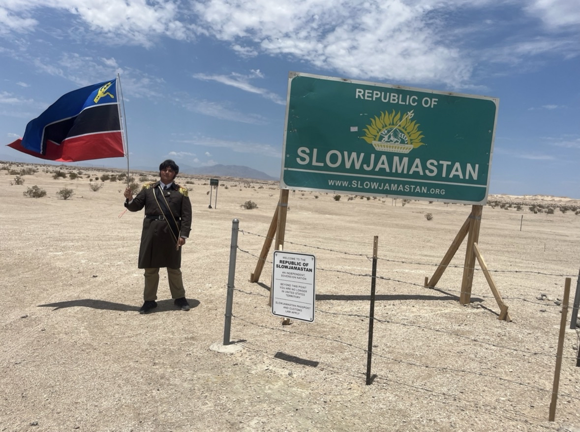 A picture of me waving the flag of my micronation outside of Slowjamastan